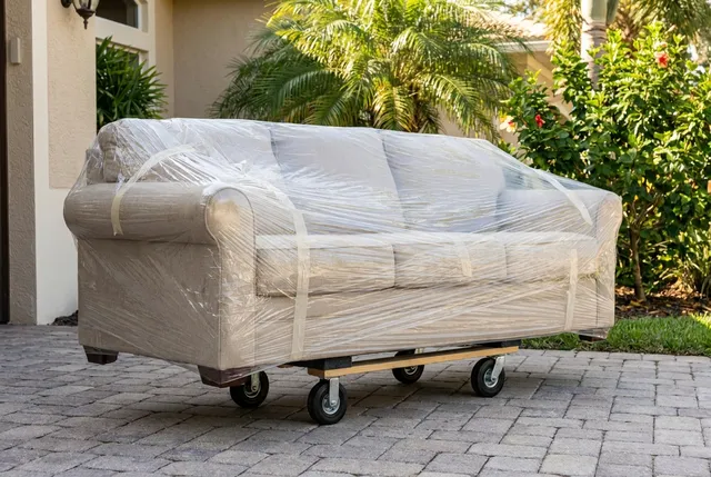 Two movers delivering a single sofa to a villa in Bali